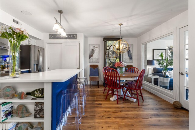 dining room with a wealth of natural light, dark hardwood / wood-style floors, and a notable chandelier