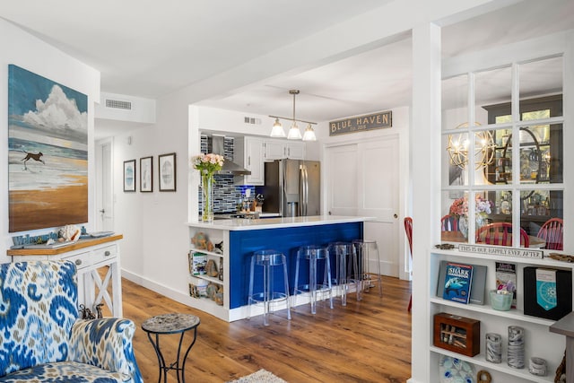 kitchen featuring a chandelier, visible vents, stainless steel refrigerator with ice dispenser, and wood finished floors