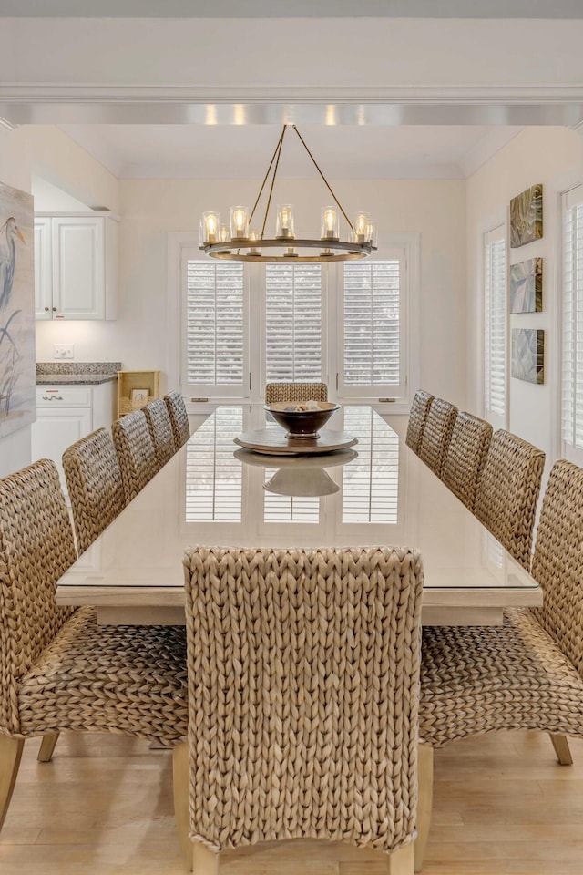 dining space with light wood-type flooring and a notable chandelier