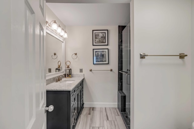 bathroom featuring a stall shower, vanity, and baseboards