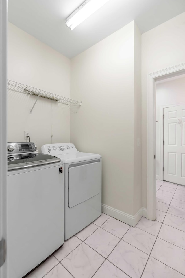 laundry room with baseboards and washing machine and dryer