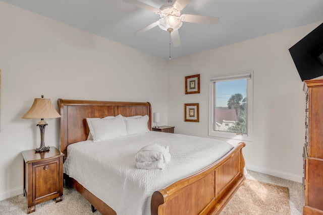 bedroom with baseboards, ceiling fan, and light colored carpet