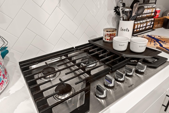 room details featuring backsplash and stainless steel gas cooktop