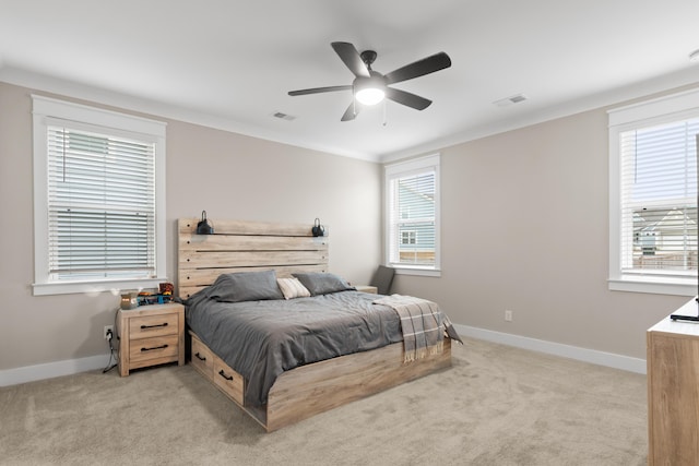 carpeted bedroom featuring ceiling fan and crown molding