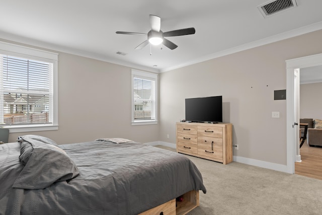 bedroom with ceiling fan, crown molding, and light carpet