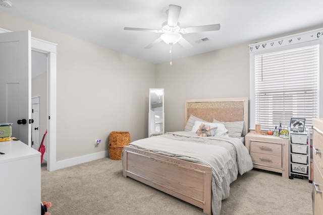 bedroom featuring light carpet, multiple windows, and ceiling fan