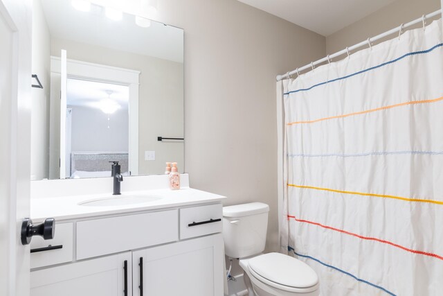 bathroom featuring walk in shower, vanity, and toilet