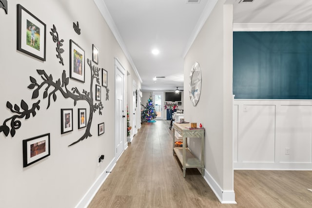 hallway featuring light hardwood / wood-style floors and crown molding