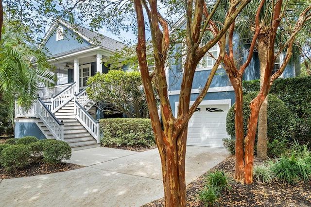 view of front of property featuring a garage, ceiling fan, stairs, and a porch