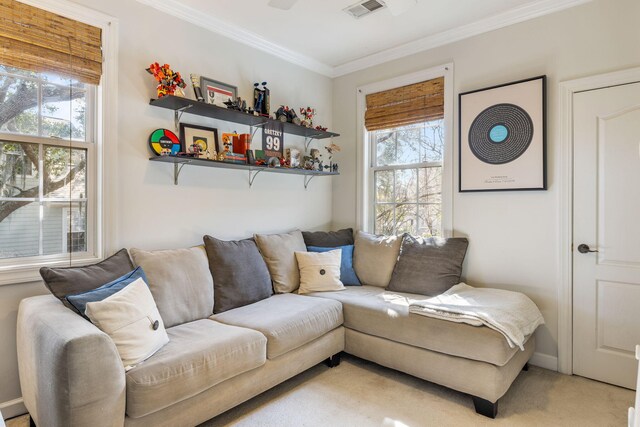 living area with ornamental molding, a wealth of natural light, visible vents, and light carpet