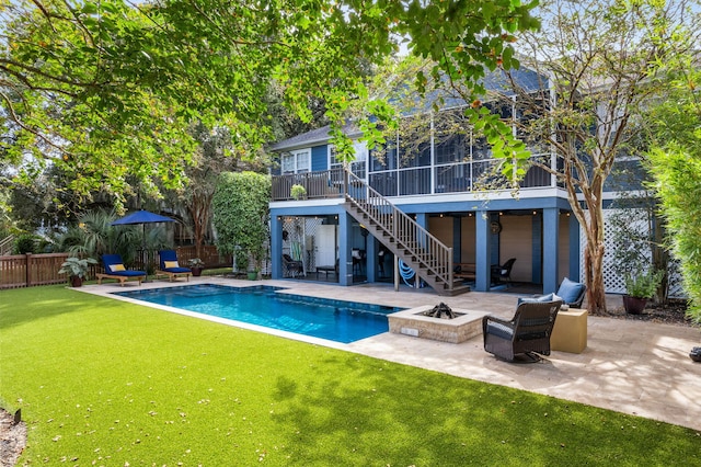 rear view of house featuring an outdoor fire pit, fence, stairs, a yard, and a patio area