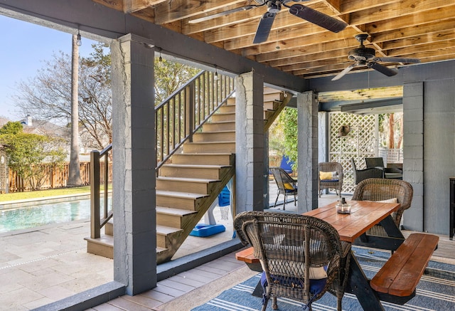 wooden deck featuring a patio, fence, a ceiling fan, stairway, and outdoor dining space