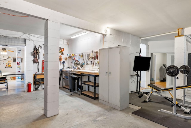 basement with concrete block wall and a workshop area