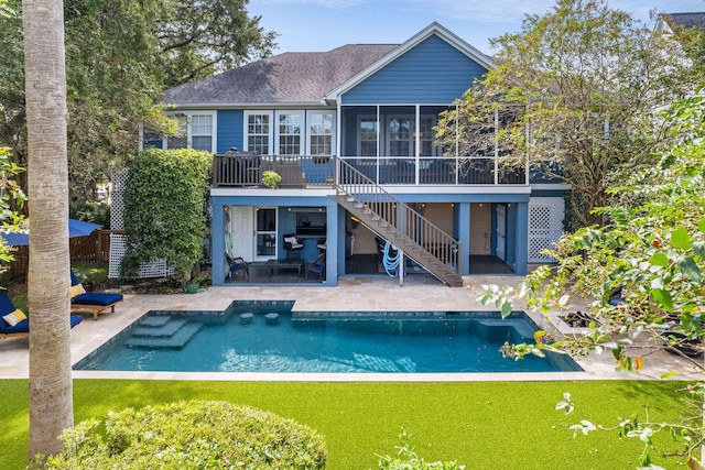 back of house with stairs, a patio, a yard, and a sunroom