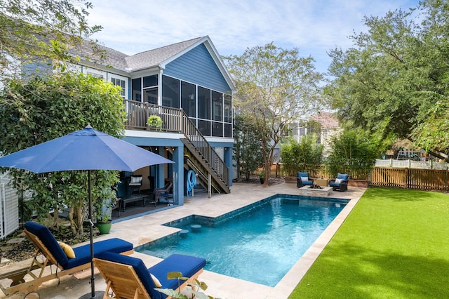 back of property with a lawn, stairway, a sunroom, a patio area, and fence