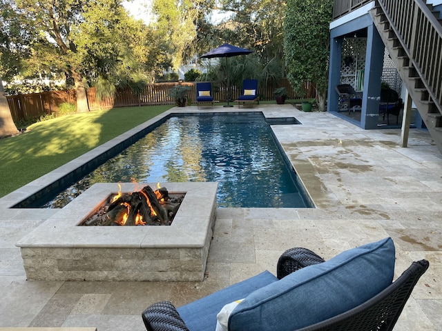 view of pool with a fenced in pool, a patio, a lawn, a fenced backyard, and a fire pit