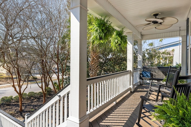 wooden deck featuring covered porch and a ceiling fan