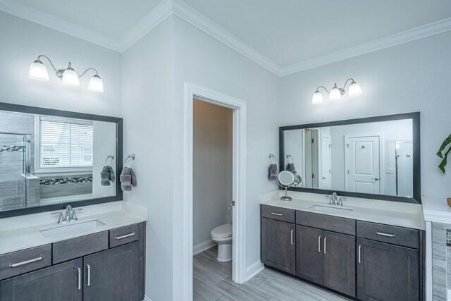 2234 Mother Of Pearl Dr, Mount Pleasant, SC 29466 - bathroom with two vanities, crown molding, toilet, tiled shower, and baseboards