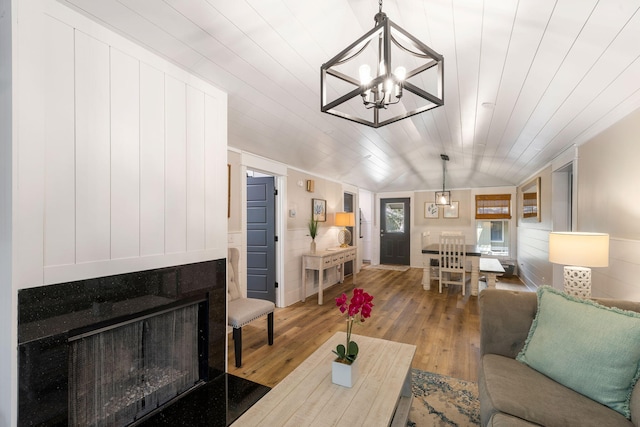 living room with hardwood / wood-style floors, an inviting chandelier, wooden ceiling, and lofted ceiling