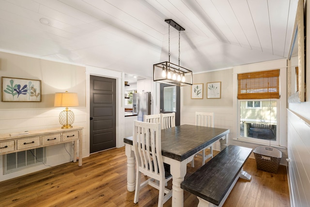 dining space featuring visible vents, ornamental molding, light wood-style floors, wood ceiling, and vaulted ceiling
