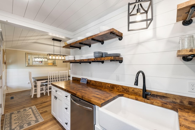 kitchen with a sink, wooden counters, open shelves, wood finished floors, and stainless steel dishwasher