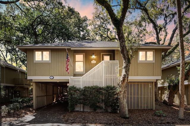 view of front of house featuring a carport, stairway, and driveway