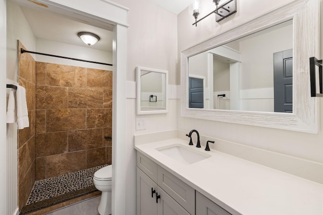 bathroom with a stall shower, toilet, and vanity