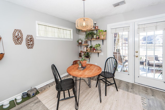 dining space with light hardwood / wood-style flooring and a textured ceiling