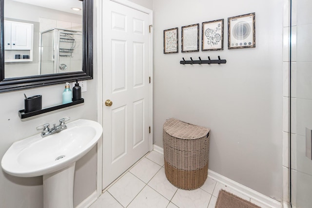 bathroom featuring tile patterned flooring, an enclosed shower, and sink