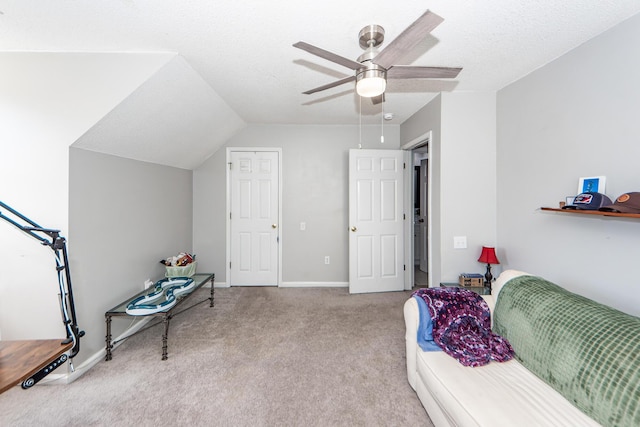 interior space featuring ceiling fan, lofted ceiling, light carpet, and a textured ceiling