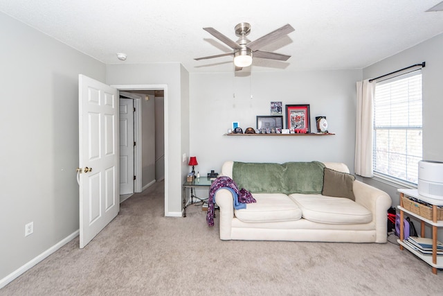 carpeted living room featuring ceiling fan and a textured ceiling