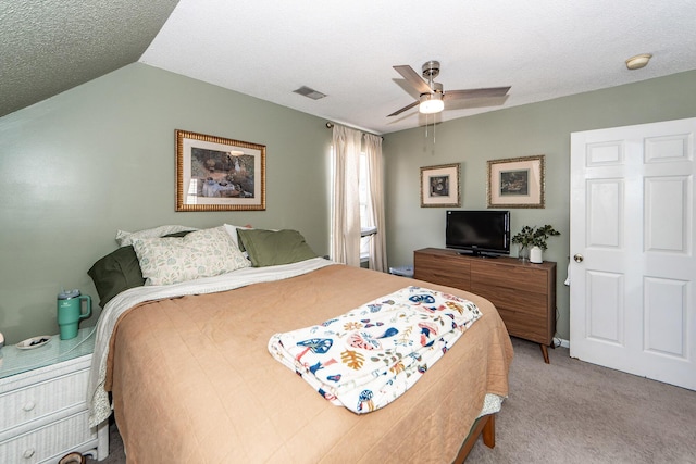 bedroom with lofted ceiling, ceiling fan, light colored carpet, and a textured ceiling