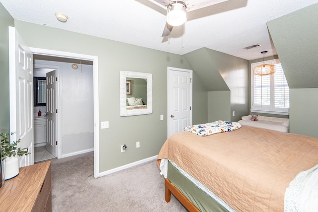 bedroom with light carpet, connected bathroom, vaulted ceiling, and a textured ceiling