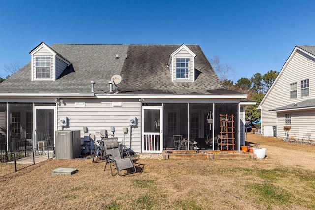 rear view of house featuring a yard and a sunroom