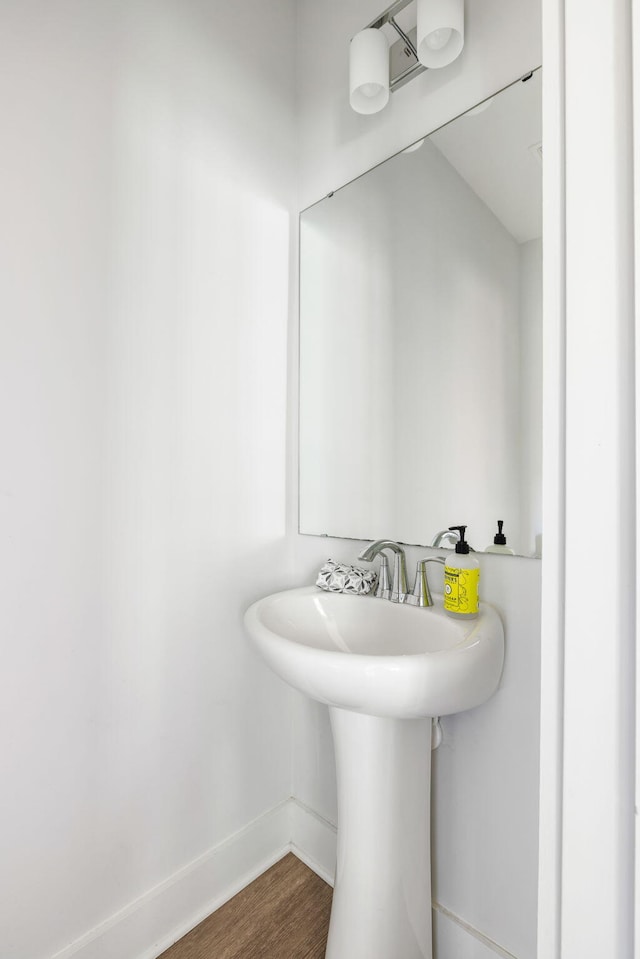 bathroom with wood finished floors and baseboards