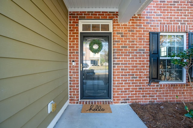 property entrance featuring brick siding