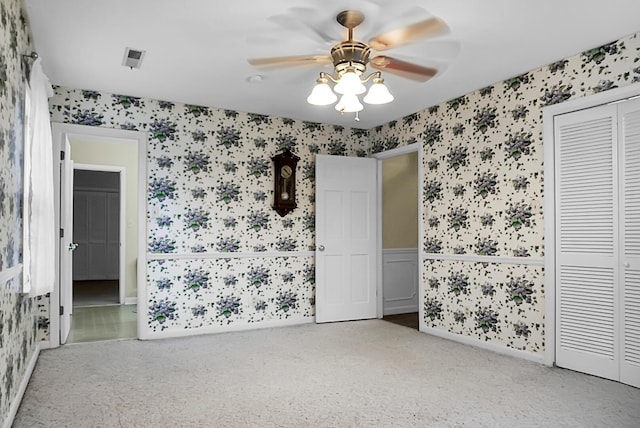 unfurnished bedroom with a ceiling fan, ensuite bath, baseboards, a closet, and wallpapered walls
