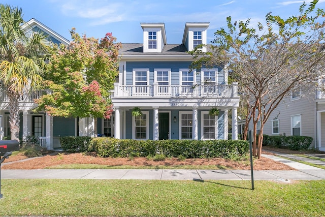 view of front facade featuring a balcony and a front yard