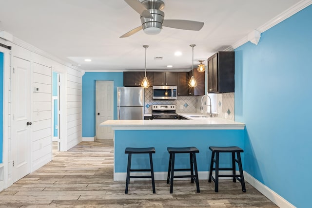 kitchen with decorative backsplash, appliances with stainless steel finishes, crown molding, and a sink