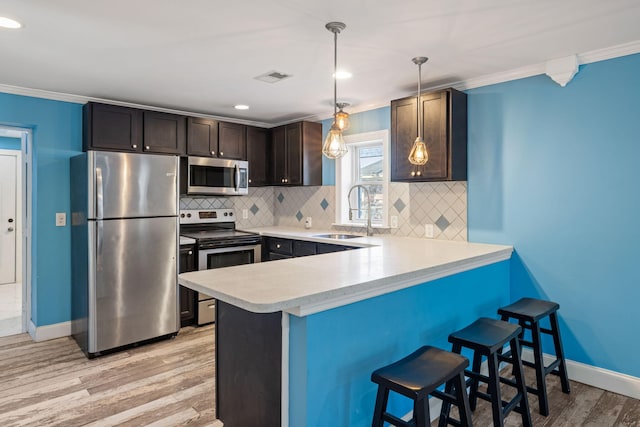 kitchen with visible vents, a sink, light countertops, appliances with stainless steel finishes, and crown molding