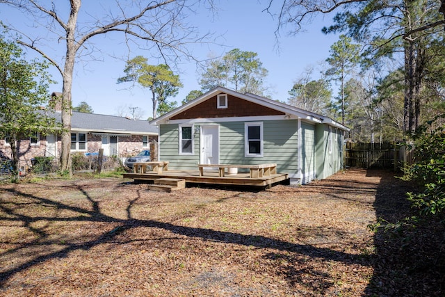 back of house featuring fence and a wooden deck