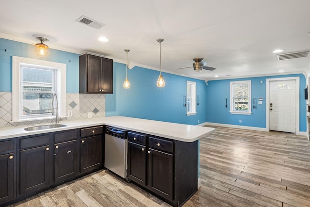 kitchen featuring stainless steel dishwasher, a peninsula, visible vents, and a sink