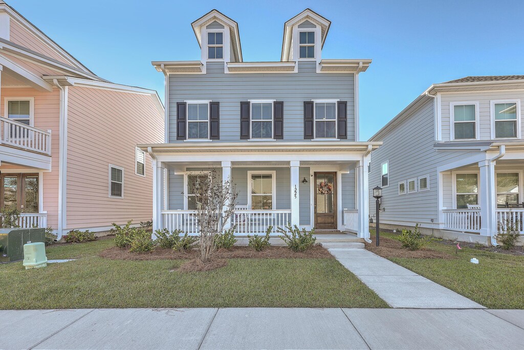 view of front facade featuring a porch, a front lawn, and cooling unit