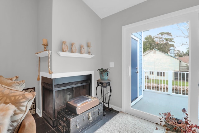 interior space featuring lofted ceiling, a multi sided fireplace, access to outside, baseboards, and tile patterned floors