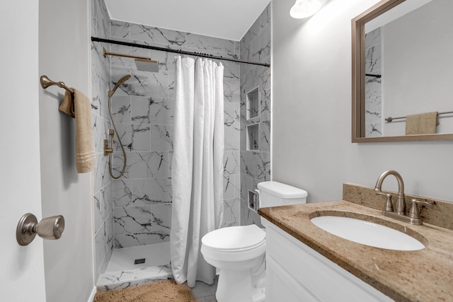 bathroom featuring vanity, a shower stall, and toilet