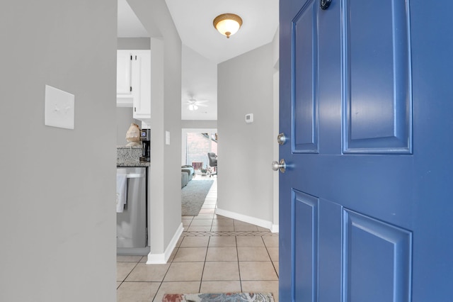 foyer featuring a ceiling fan, baseboards, and light tile patterned floors