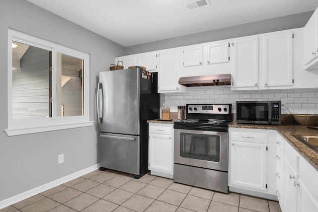 kitchen featuring wall chimney range hood, visible vents, stainless steel appliances, and backsplash