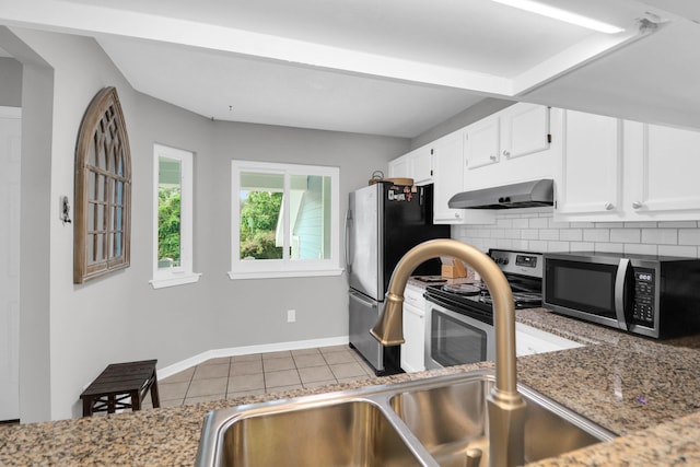 kitchen featuring white cabinets, appliances with stainless steel finishes, backsplash, tile patterned floors, and wall chimney exhaust hood