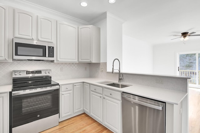 kitchen featuring white cabinetry, appliances with stainless steel finishes, sink, and kitchen peninsula