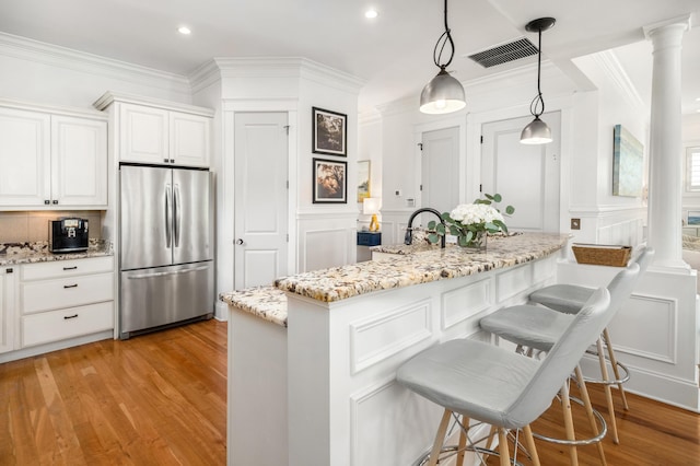 1543 Wando Landing St, Charleston, SC 29492 - kitchen featuring freestanding refrigerator, a decorative wall, ornamental molding, a kitchen breakfast bar, and ornate columns
